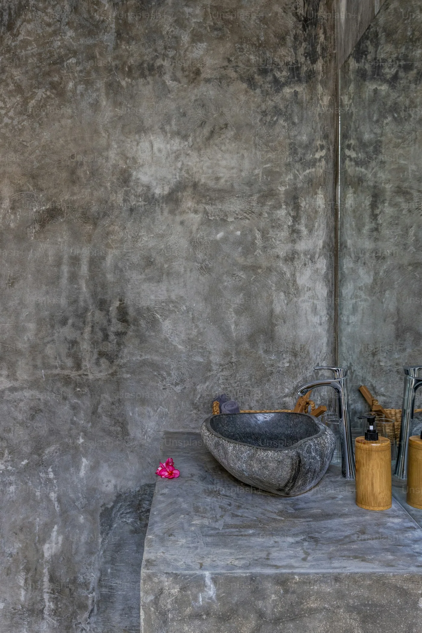 Betonnen wasbak tegen een ruwe betonwand